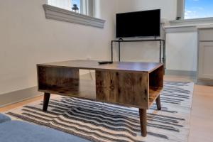 a wooden coffee table in a living room with a tv at Bright and Modern Studio in Louisville # 301 in Louisville