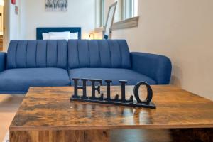 a blue couch and a table with a hello sign on it at Bright and Modern Studio in Louisville # 301 in Louisville +51 photos