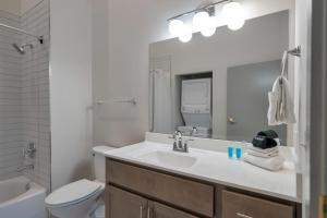 a bathroom with a sink and a toilet and a mirror at Bright and Modern Studio in Louisville # 301 in Louisville