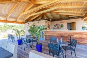 a patio with tables and chairs and a bar at Résidence Les Terrasses de Rondinara in Bonifacio