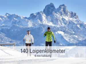 two people standing on top of a snow covered mountain at Apartments Tannheim - bei Birgit Mariacher - inklusive Sommerbergbahnen - Infrarotsauna & Brötchenservice - zentral mit Bergblick in Tannheim