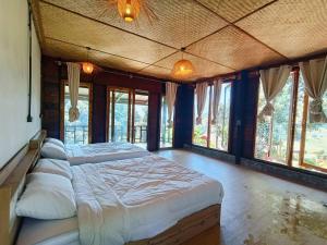 a large bedroom with a large bed with windows at Motho Homestay in Chom Thong