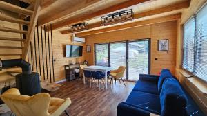 AdamowにあるKrólikowe Chatyの青いソファとテーブルのあるリビングルーム