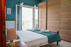 a bedroom with a bed and a large window at Villa Sunrise apartment in Gouvia +24 photos