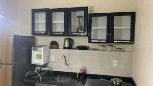 a kitchen with black cabinets and a sink at Top Coliving II in Cuiabá
