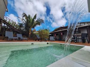 a fountain in the middle of a swimming pool at Flats Baia dos Porcos in Fernando de Noronha
