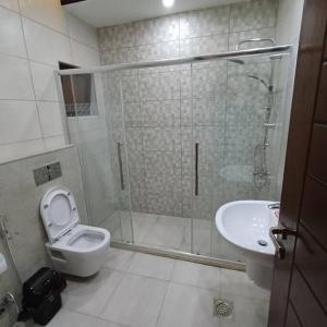 a bathroom with a shower and a toilet and a sink at Laperla luxury family apartment one in Amman +22 photos