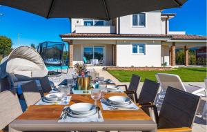 - une grande table avec des chaises et un parasol sur la terrasse dans l'établissement 4 Bedroom Stunning Home In Nedescina, à Nedeščina 31 autres photos