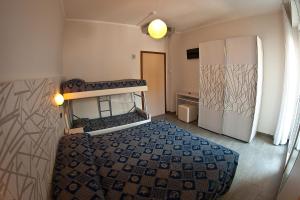 a small bedroom with a bed and a refrigerator at Hotel Alba D'Oro in Bellaria-Igea Marina