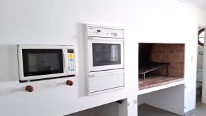 eine Küche mit 2 Mikrowellen und einem Kamin in der Unterkunft Departamento de dos plantas en zona centro San José, Entre Ríos in San José + 27 Fotos