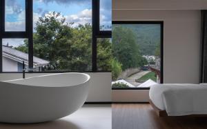 a white bathroom with a tub and a large window at Neo-garden in Dali +90 photos