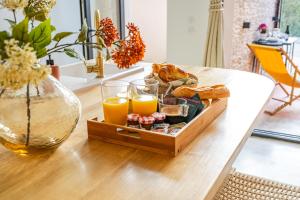 a tray of food and orange juice on a table at Hermès - Loft avec jacuzzi & terrasse in Nyons