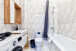 a bathroom with a toilet and a tub and a sink at RAISSON APARTHOTEL AM85 Хан Шатыр in Taldykolʼ +26 photos