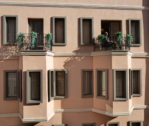 a person sitting on a balcony of a building at Hotel Des Arts Galata in Istanbul