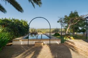 un arco sopra una piscina in un cortile di Casa rural Hacienda San Felipe a Gerena