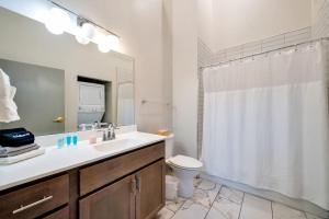 Un baño con lavabo, inodoro y ducha. en Bright and Modern Studio in Louisville # 307, en Louisville