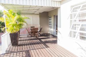 a patio with a table and chairs on a deck at Nahoon Beach Villas Self Catering Apartments in East London