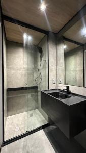 a bathroom with a glass shower and a sink at Apto Beira-Mar com Vista Mar - NT1206 in Maceió