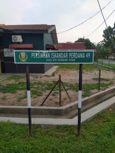 a street sign in front of a building at Atbas Homestay No 1 in Seri Iskandar