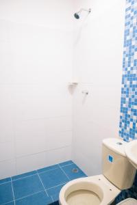 bagno con servizi igienici bianchi e pavimento piastrellato blu. di Casa Hemma a Santa Marta