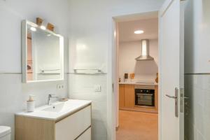 a white bathroom with a sink and a mirror at Casa Fela in Famara +17 photos