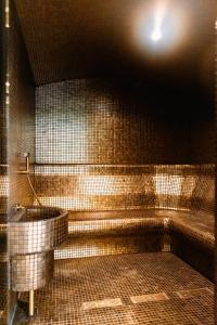 een betegelde badkamer met een bad en een wastafel bij Matei Basarab Chic Studio in Boekarest