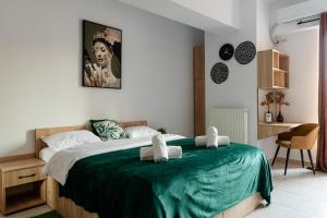 een slaapkamer met een groot bed en een groene deken bij Matei Basarab Chic Studio in Boekarest +37 foto's