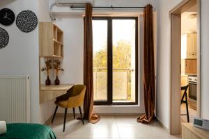 a bedroom with a desk and a large window at Matei Basarab Chic Studio in Bucharest