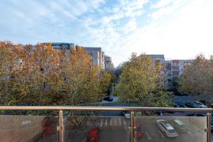 uitzicht op een parkeerplaats met bomen en gebouwen bij Matei Basarab Chic Studio in Boekarest