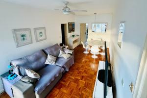 a living room with a couch and a table at Vista ao Mar Praia Pitangueiras Servico de praia Garagem in Guarujá