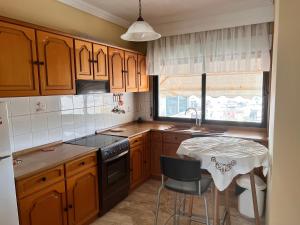 una cucina con mobili in legno, un tavolo e un lavandino di Surrounded View Family - with Private Parking a Kavala
