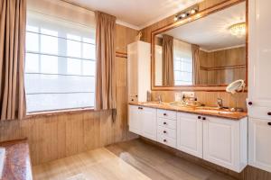 a bathroom with a sink and a large mirror at Villa Blauw in De Panne +13 photos