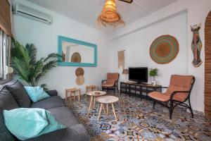 ein Wohnzimmer mit Sofa, Sesseln und Fernseher in der Unterkunft Casa Gecko in Benalmádena