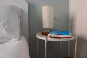 a table with a lamp and books on it next to a bed at Your Sea Escape in Riva Trigoso