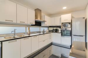 een witte keuken met witte kasten en apparaten bij Villa Nogueira V with Private Pool by Holiday Rental Madeira in Funchal