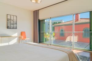 een slaapkamer met een bed en een groot raam bij Villa Nogueira V with Private Pool by Holiday Rental Madeira in Funchal +23 foto's