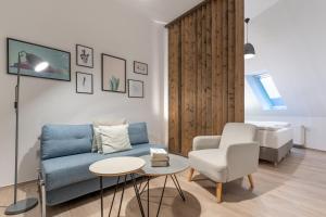 a living room with a blue couch and a chair at BENSIMON apartments Prenzlauer Berg in Berlin