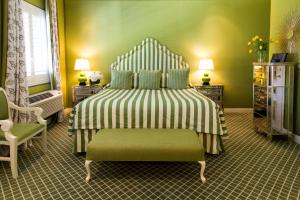 a room with a bed, a chair, and a lamp at The Chesterfield Hotel Palm Beach in Palm Beach