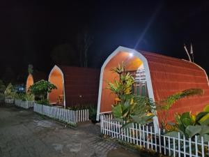 a small house with a red roof at night at Indah Damai Cottages in Sidomukti