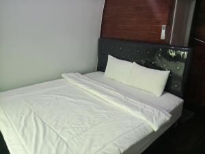 a bed with white sheets and pillows in a room at Indah Damai Cottages in Sidomukti