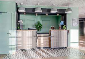 ein Büro mit grünen Wänden und einer Lobby in der Unterkunft B&B HOTEL Bordeaux Saint André de Cubzac in Saint-André-de-Cubzac