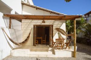 un porche de una casa con mesa y sillas en Dunas Pipa acomodações, en Pipa