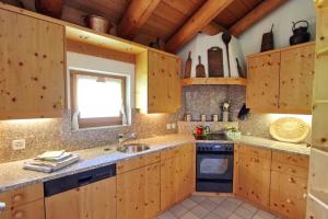 a kitchen with wooden cabinets and a sink at Apartment Cign OG in Celerina