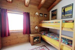 a bedroom with bunk beds in a log cabin at Apartment Cign OG in Celerina