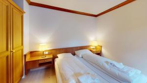 two beds in a room with two lamps on both sides at Apartment Belvair 32 in Zuoz