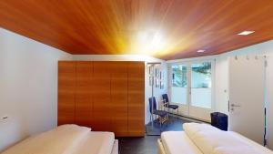 a room with two beds and a wooden wall at Apartment Quadratscha in Samedan