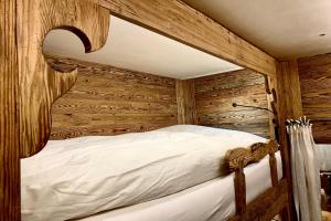 a bed in a room with wooden walls at Apartment Au Reduit 208 in St. Moritz