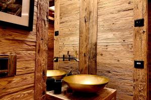 a bathroom with two sinks and a wooden wall at Apartment Au Reduit 208 in St. Moritz +6 photos