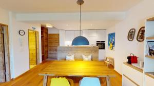 eine Küche und ein Esszimmer mit einem Holztisch und Stühlen in der Unterkunft Apartment Sungold in St. Moritz