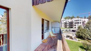 einen Balkon eines Hauses mit einem Stuhl darauf in der Unterkunft Apartment Sungold in St. Moritz + 6 Fotos